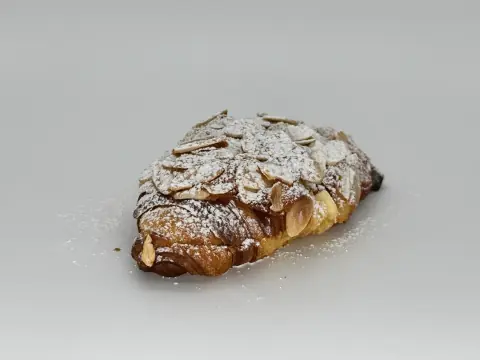 Almond Croissant - Twice-baked, filled with luscious almond cream and finished with toasted almonds. A subtle kiss of rum that lingers beautifully.