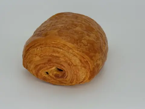 Pain Au Chocolat - Flaky shell. Rich dark belgian chocolate melting inside. Buttery, slightly sweet, and deeply satisfying.