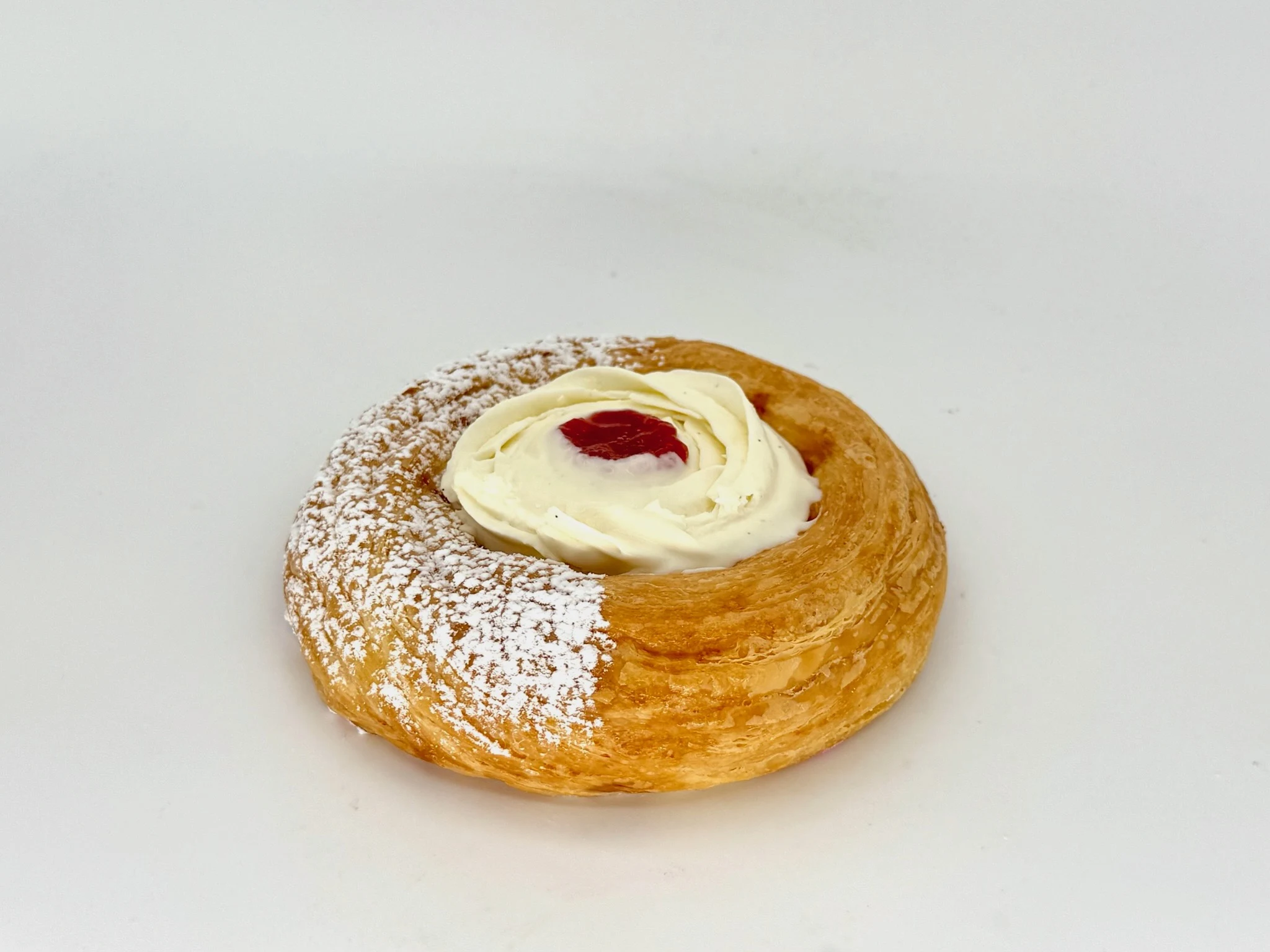Cream Cheese & Strawberry Filling Danish - Golden, flaky puff pastry spiraled into a tender ring and filled with velvety cream cheese swirled with bright strawberry jam. Finished with a generous rosette of fresh-piped cream cheese, a jewel of strawberry confit in the center, and a dusting of powdered sugar. Rich yet light — tangy, sweet, and impossible to put down.