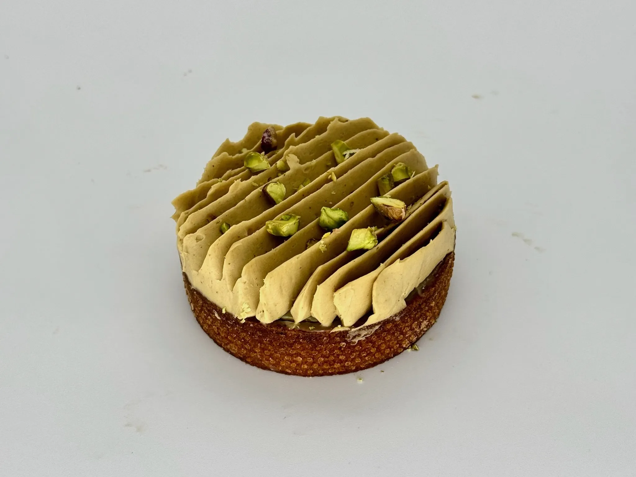 Pistachio Delight Tartlet - A true pistachio lover's dream. Crisp almond sable layered with rich pistachio frangipane, silky vanilla ganache, and finished with airy whipped pistachio ganache cream. Nutty, creamy, and luxuriously smooth with deep pistachio flavor.